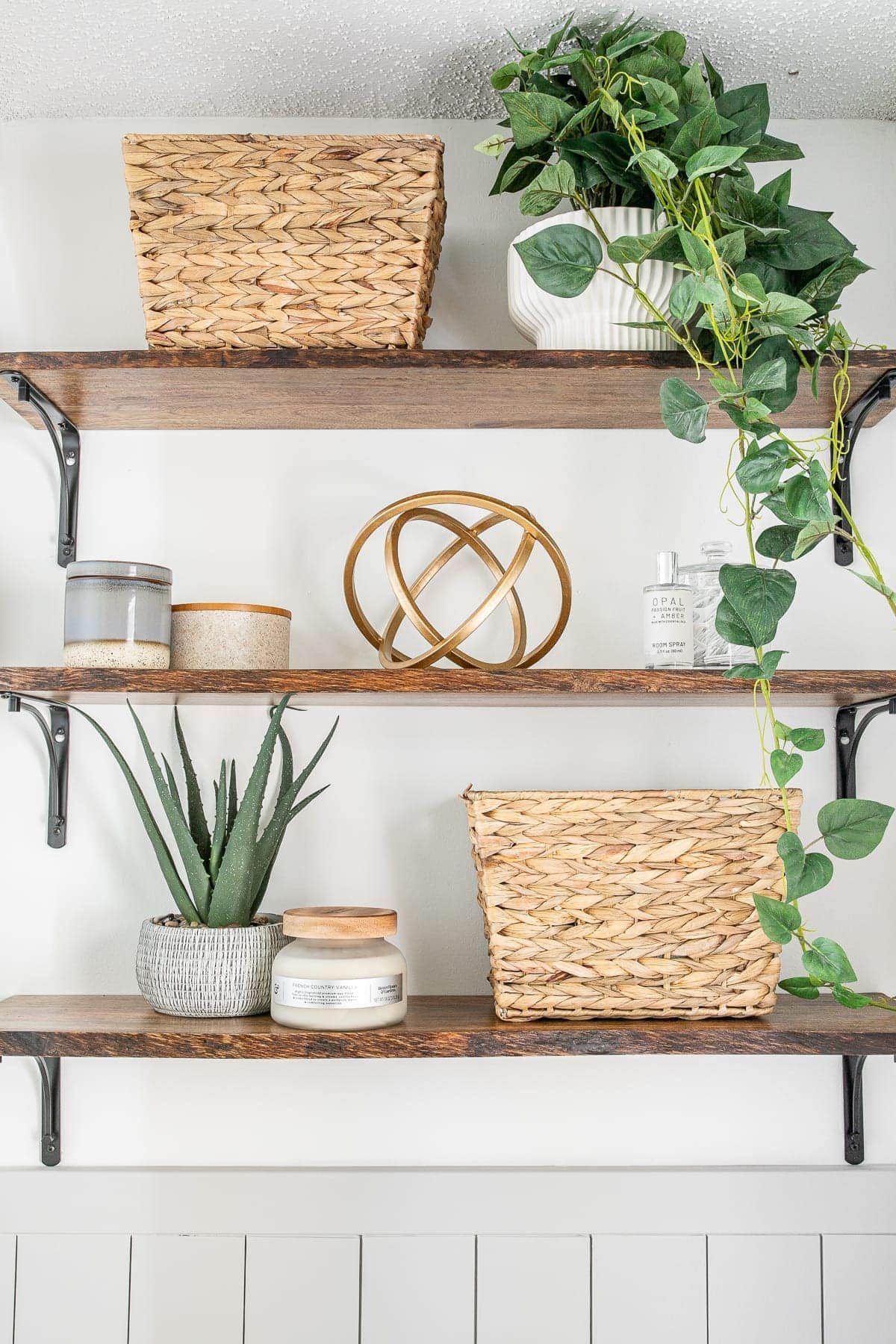 bathroom shelves with baskets, small storage, plants, and decor