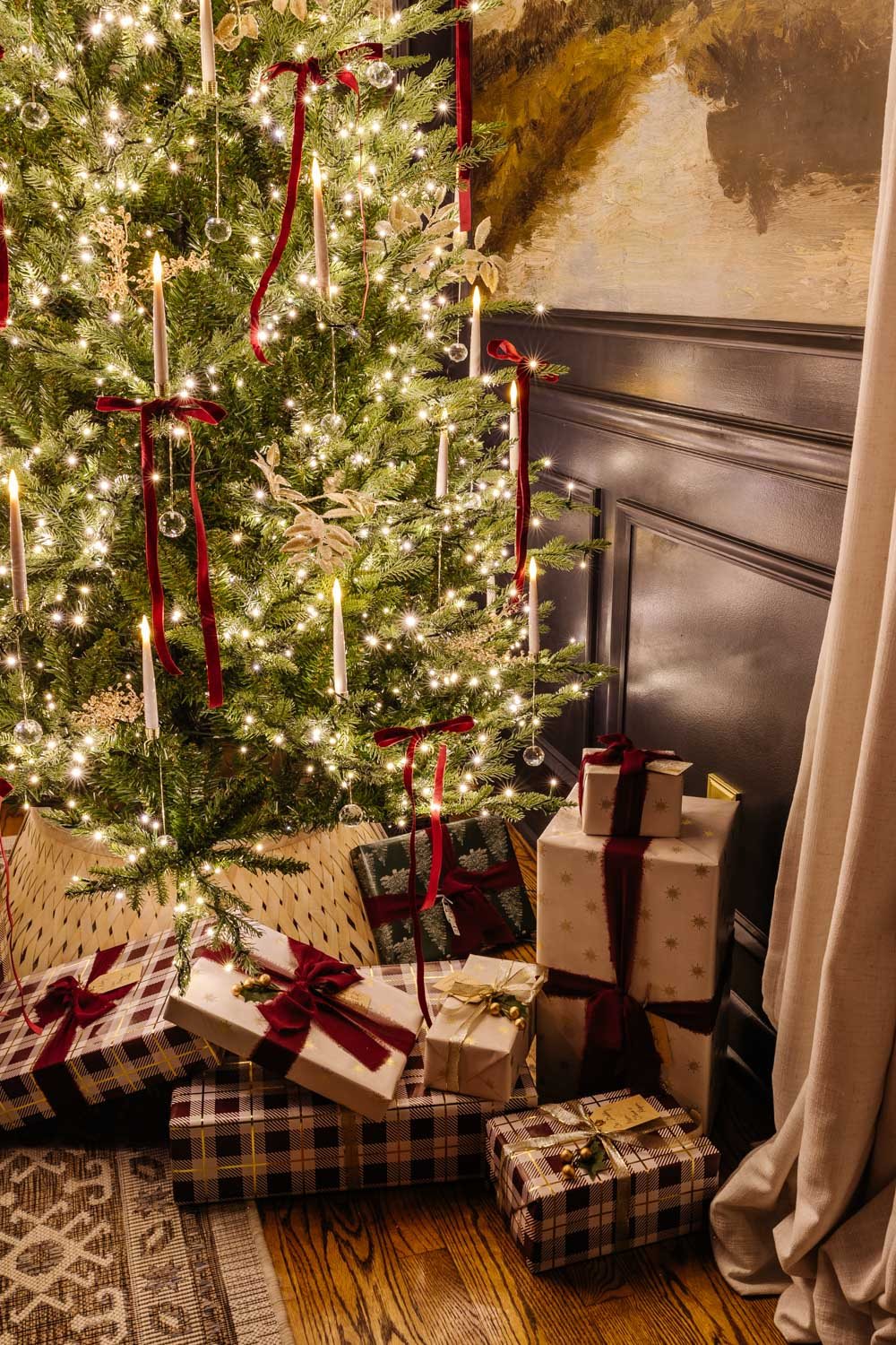 gifts under a Christmas tree at night in candlelight