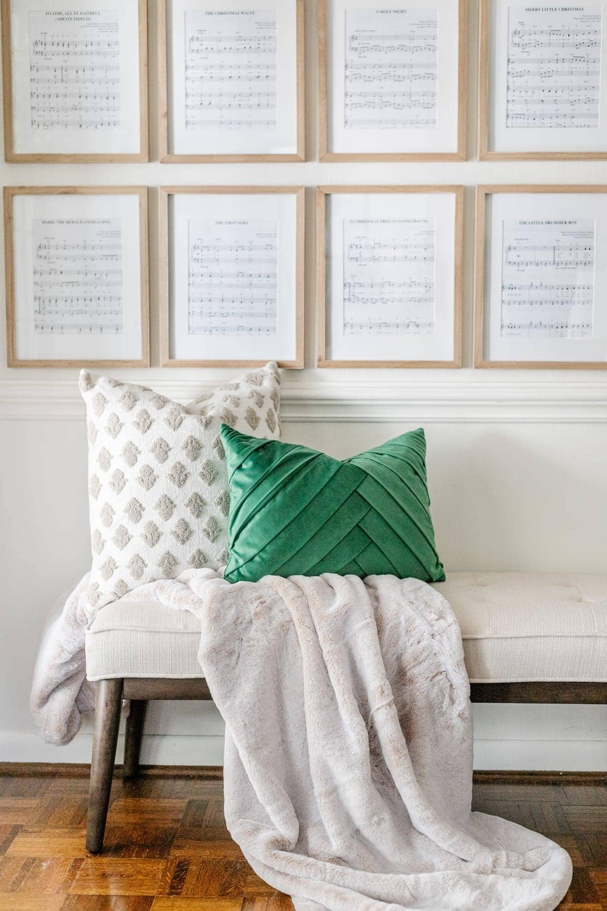 Christmas pillows on bench in entryway with sheet music art