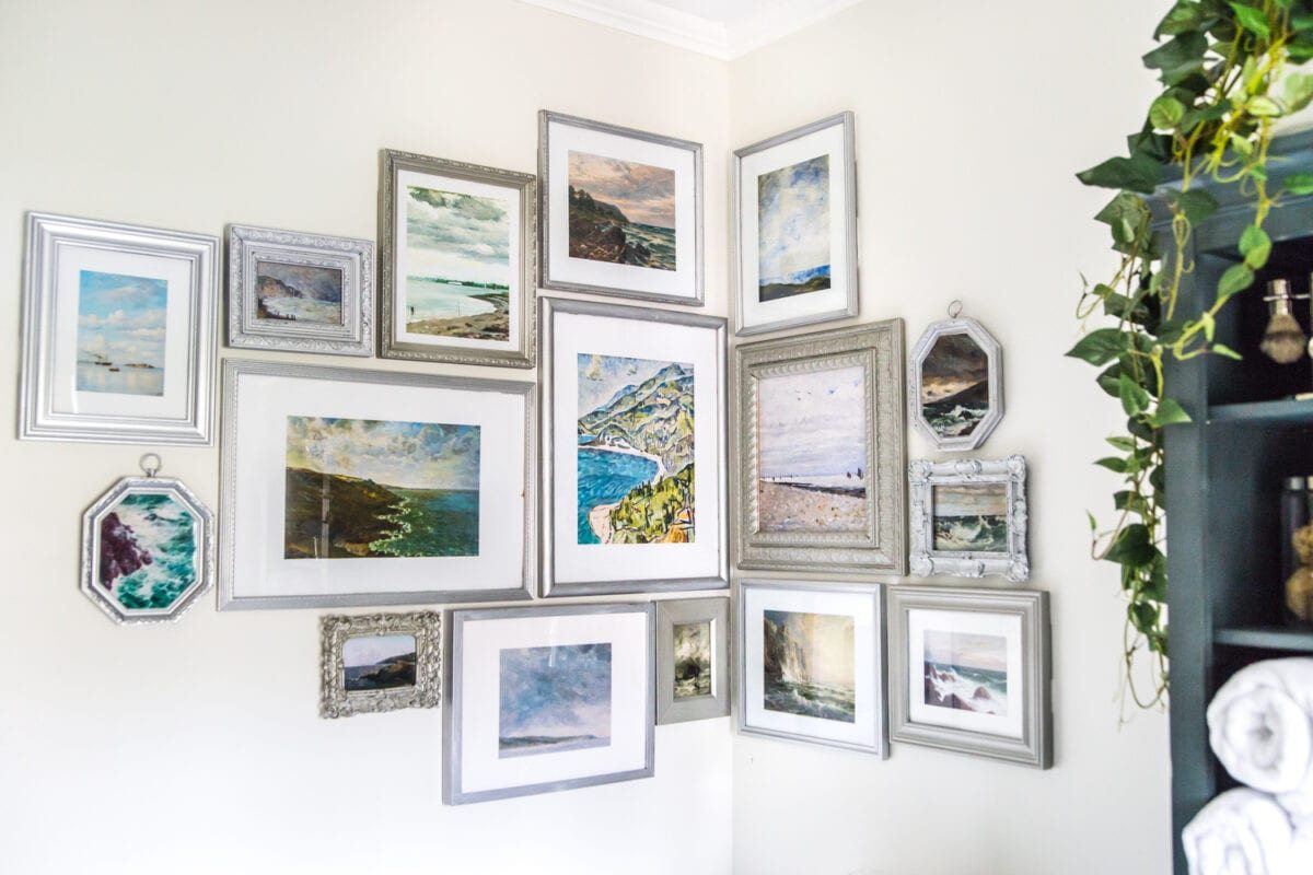 A free printable set of a coastal gallery wall featuring antique ocean paintings and how to frame them inexpensively with thrifted finds. #coastaldecor #gallerywall #bathroomart #bathroomwall #bathroomdecor #coastalart