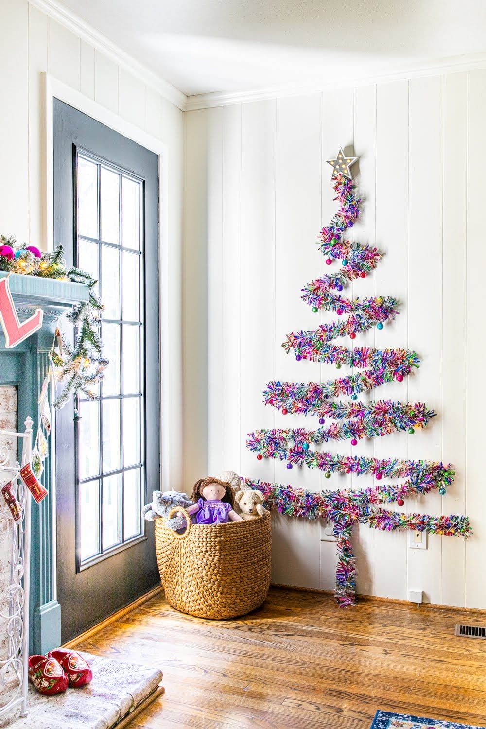 finished DIY Christmas wall tree with colorful tinsel garland in a playroom
