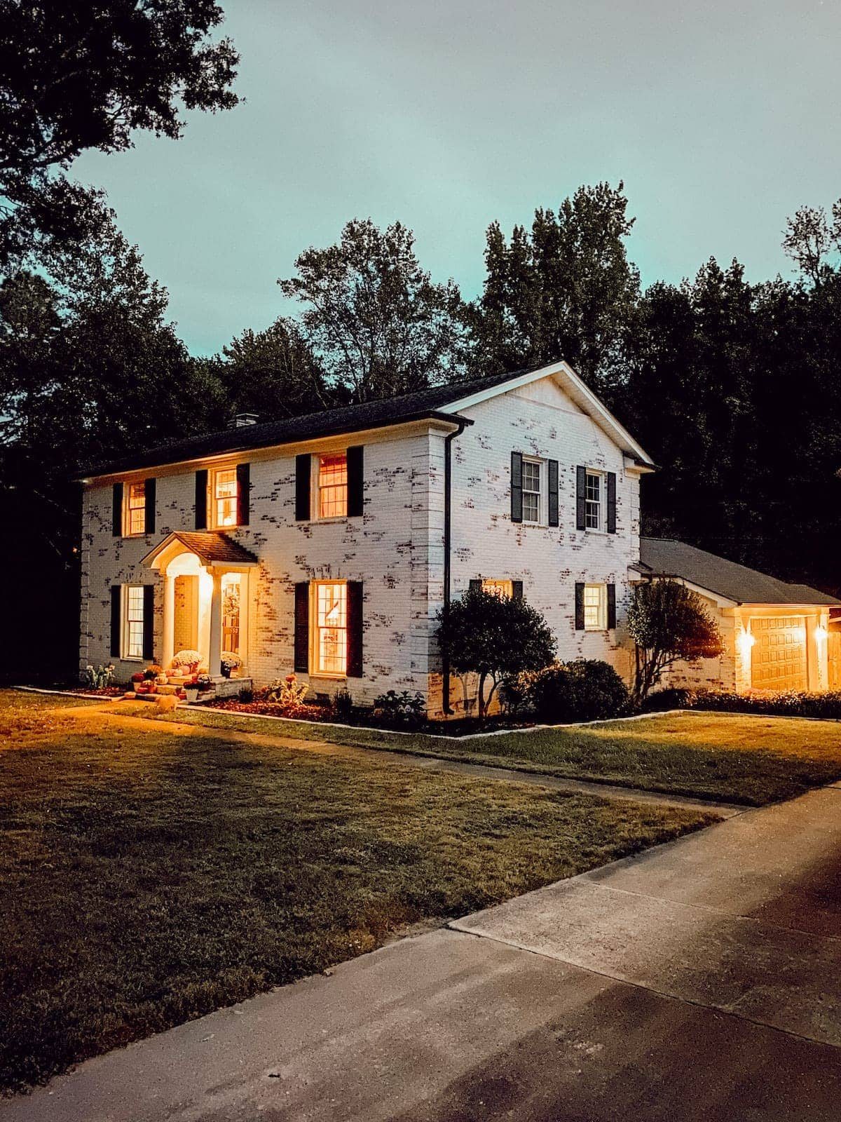 limewashed brick colonial house at night