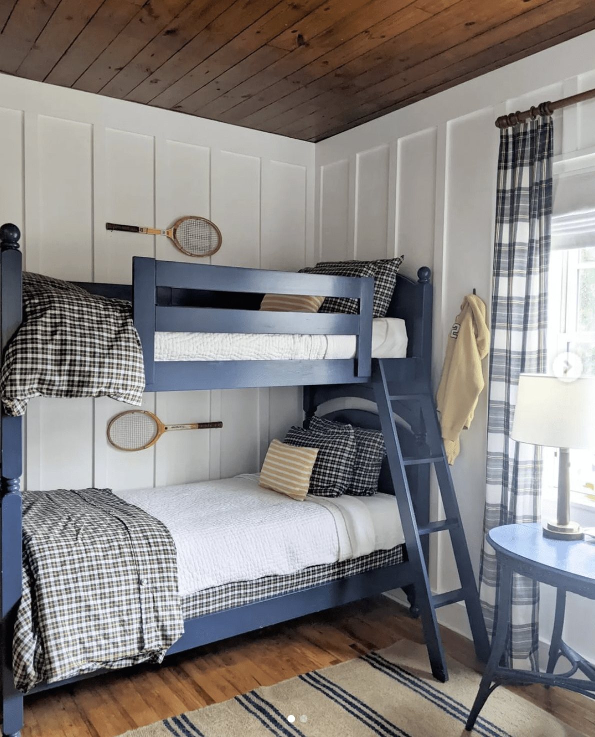 rustic boys shared bedroom with wood ceiling, board and batten walls, and plaid fabrics