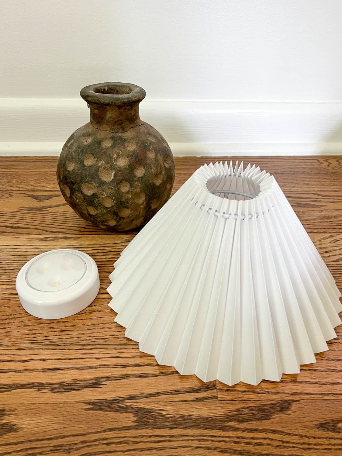 terracotta vase, pleated lamp shade, and puck light