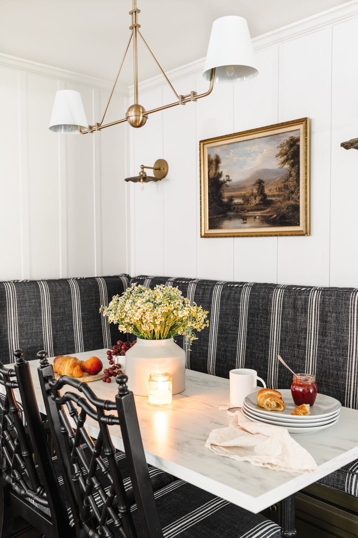bistro style marble table, white batten walls, vintage art, and bamboo dining chairs