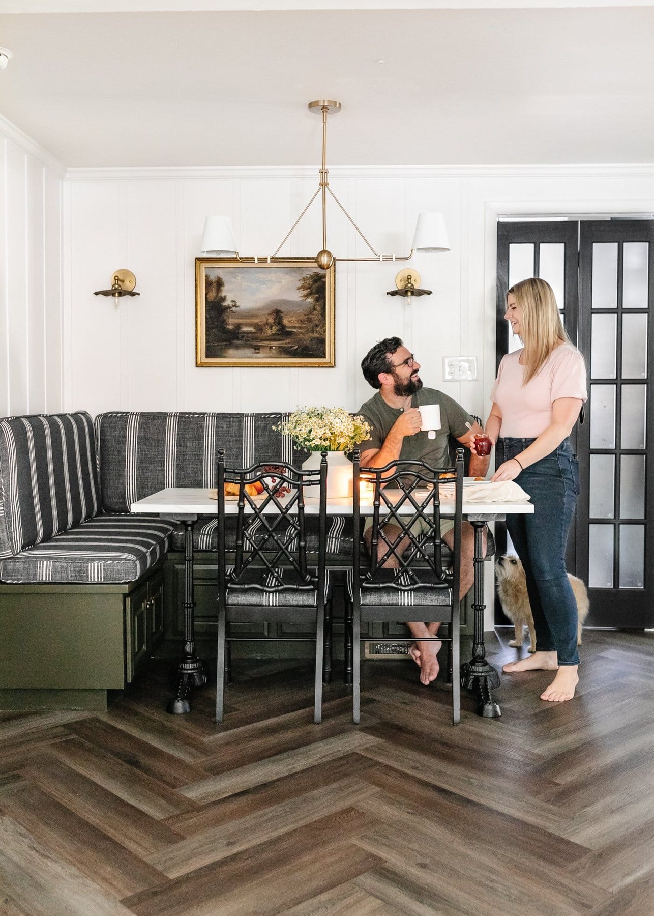 styled breakfast nook with striped banquette bench, marble table, and herringbone LVP floors from ProCore Floors