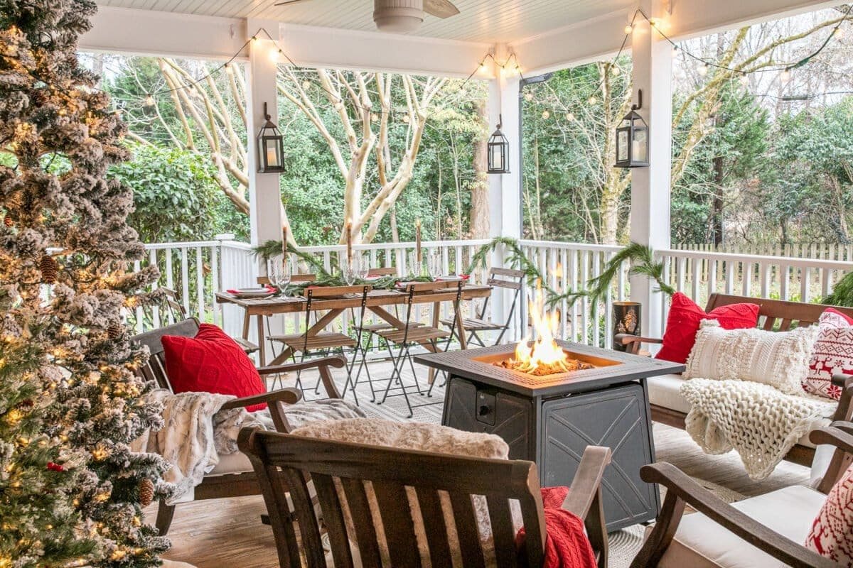 Cozy Christmas back porch with fire pit table, outdoor seating, and an outdoor dining space