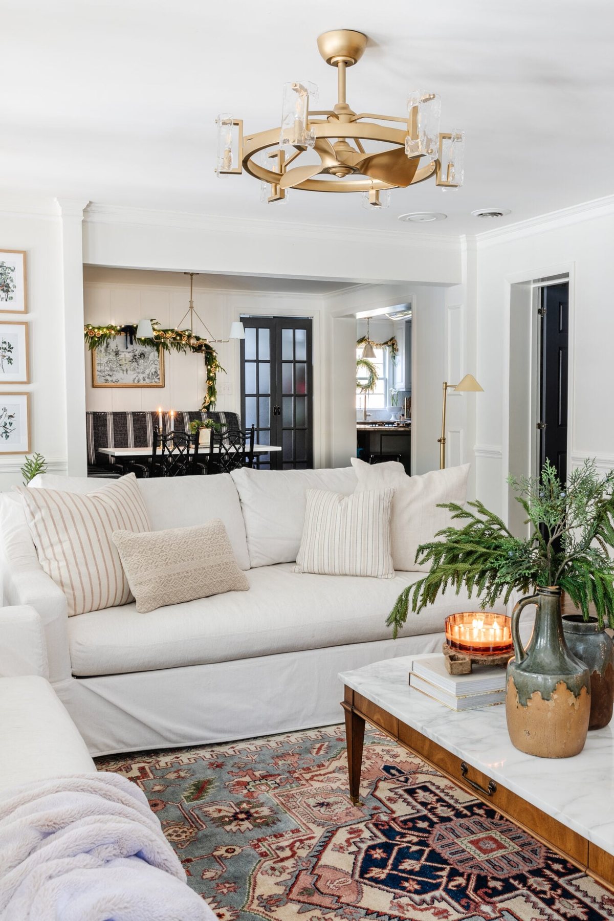 white sofa with neutral pillows and vintage rug with Christmas decor on coffee table