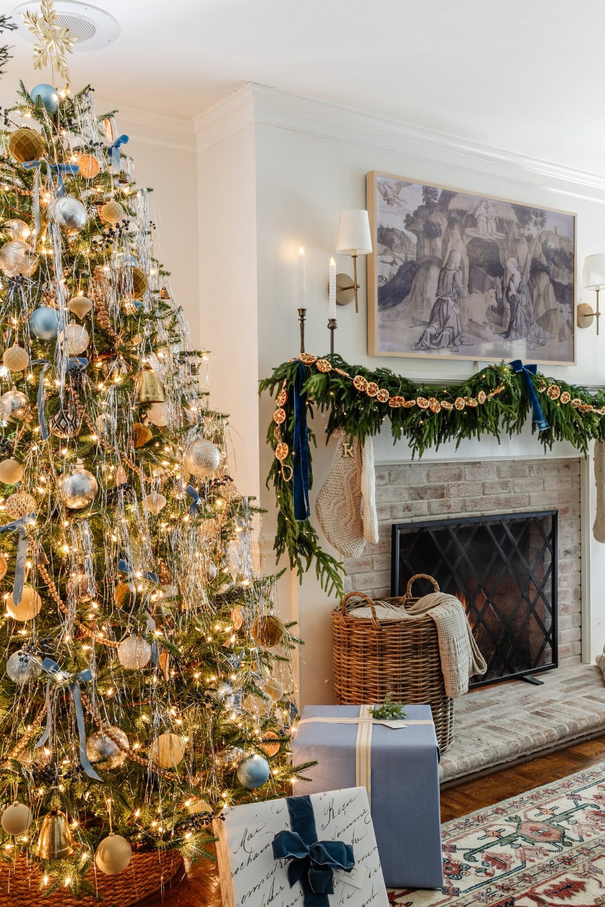 tinsel Christmas tree, limewashed brick fireplace, and mantel decorated with garland