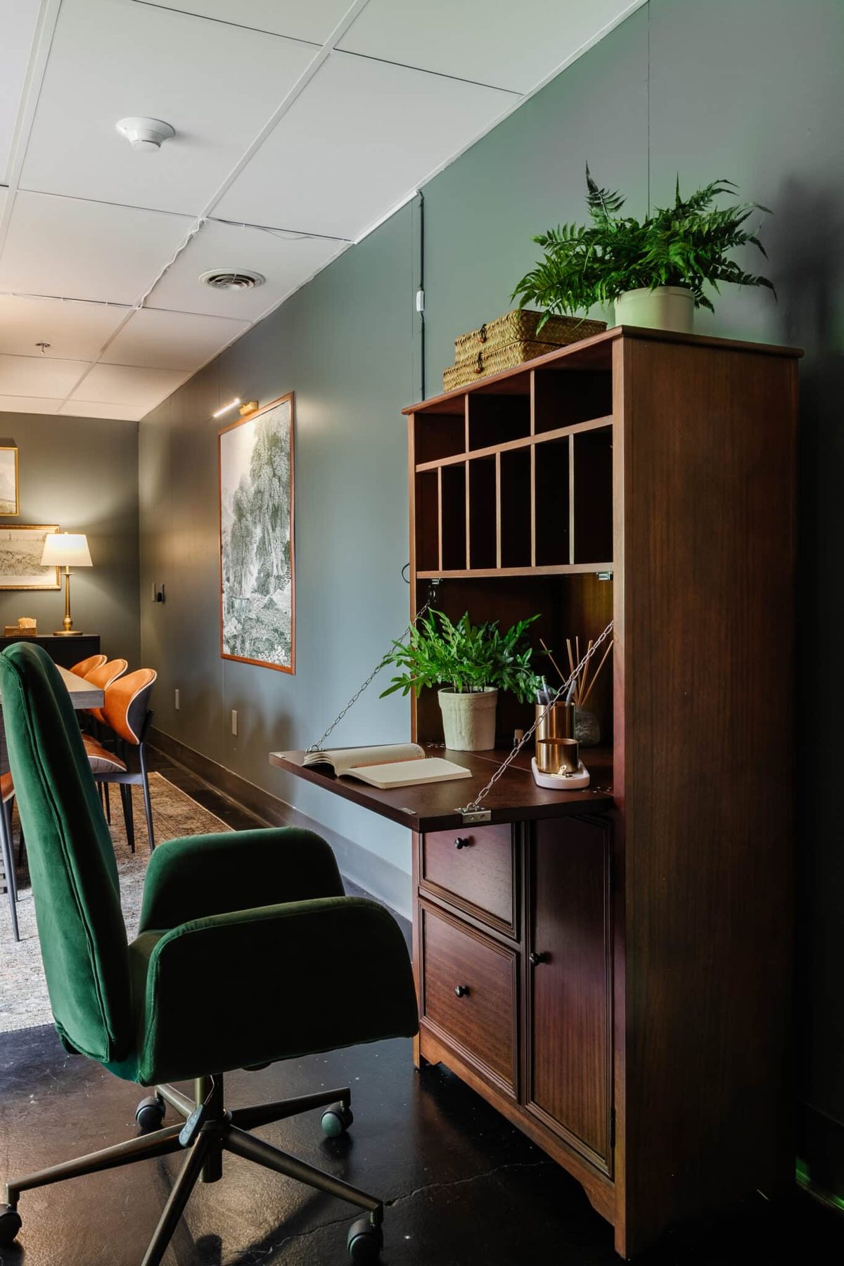 wooden secretary desk and green desk chair in an office