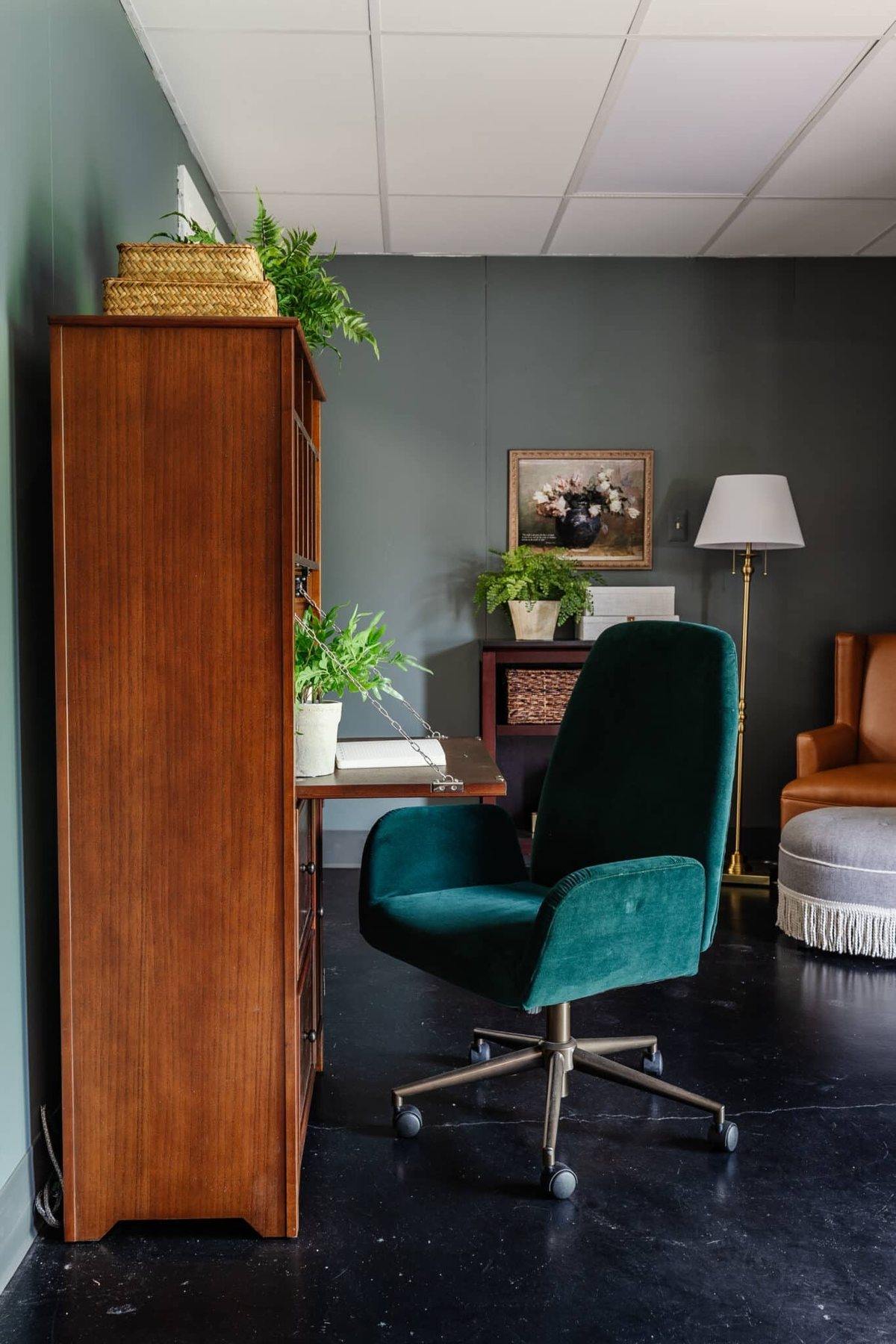 wooden secretary desk and green desk chair in an office