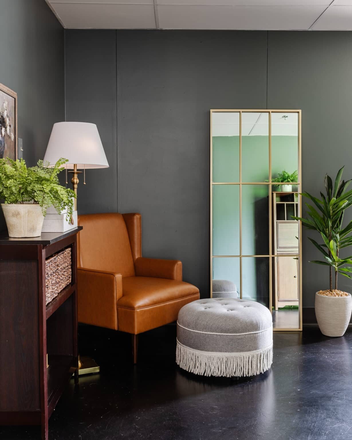 leather armchair with fringe ottoman footstool as a reading corner in an office