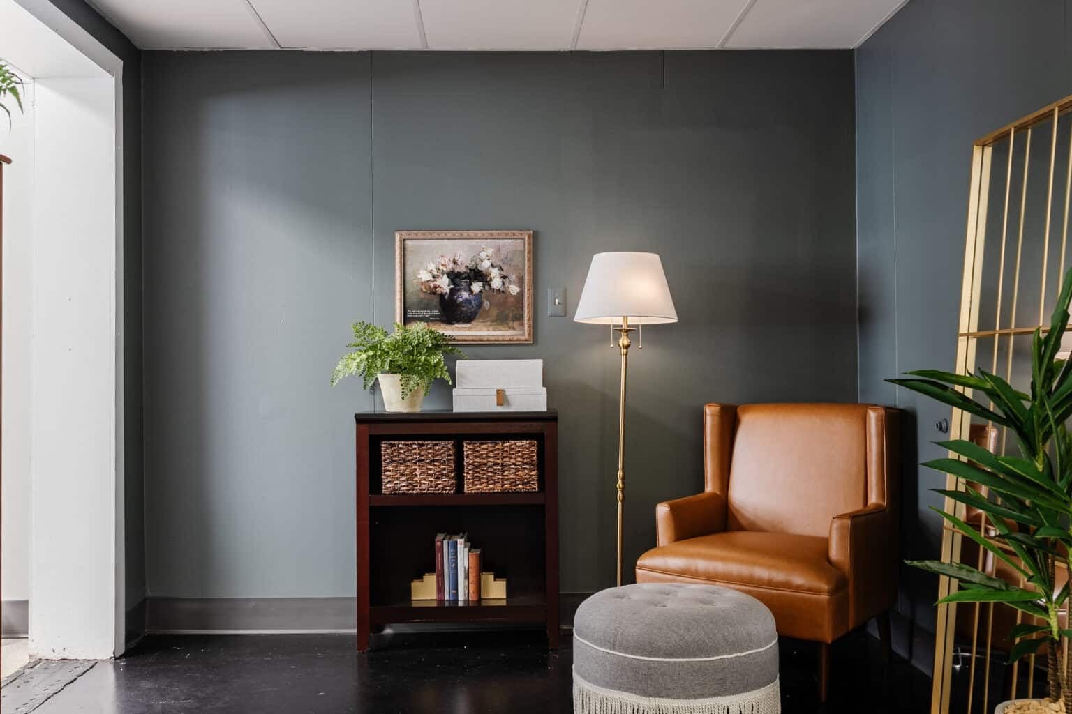 leather armchair with fringe ottoman footstool as a reading corner in an office
