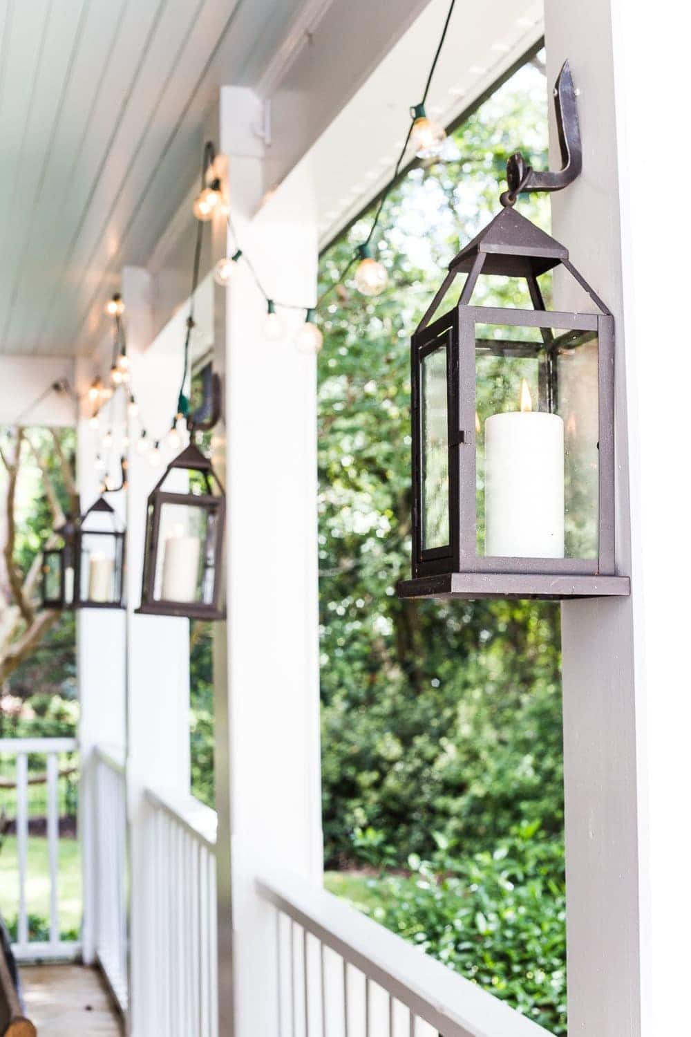 cozy fall porch with string lights and outdoor lanterns