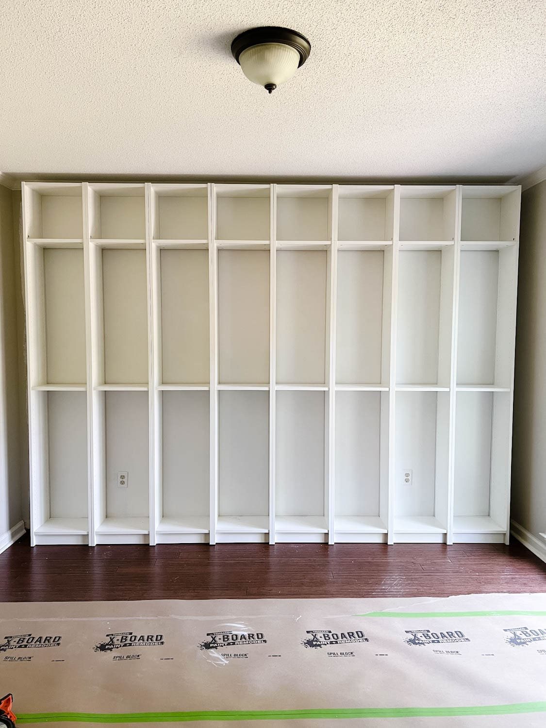 attached and anchored bookcases to the wall to make DIY built in bookshelves