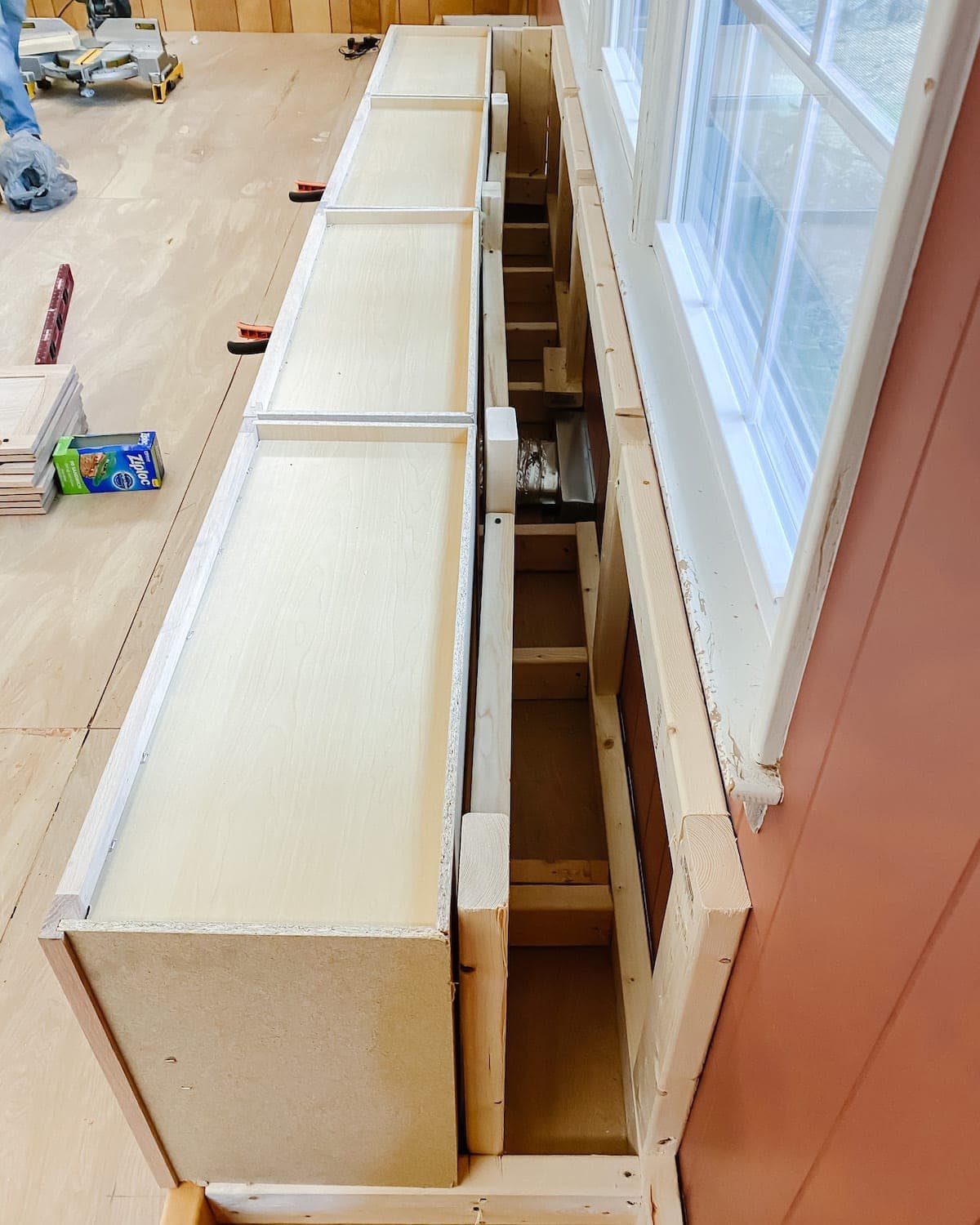 A step-by-step tutorial to build DIY built in cabinets and a window seat using inexpensive stock kitchen cabinets.