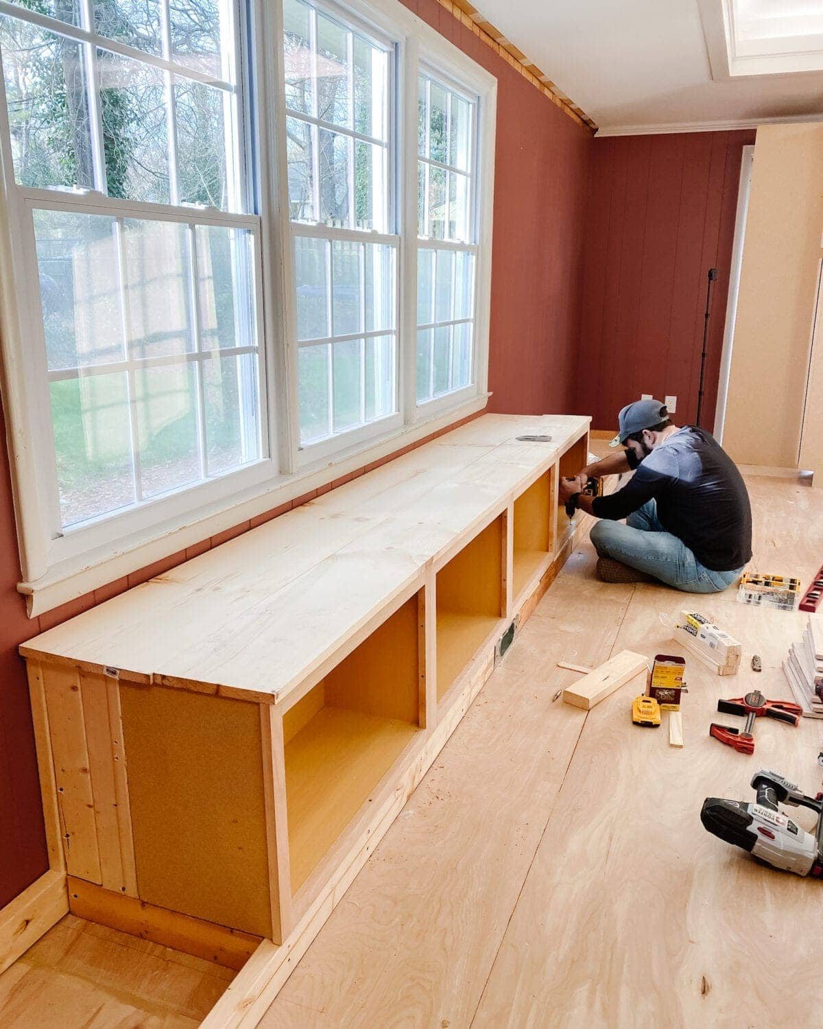 A step-by-step tutorial to build DIY built in cabinets and a window seat using inexpensive stock kitchen cabinets.