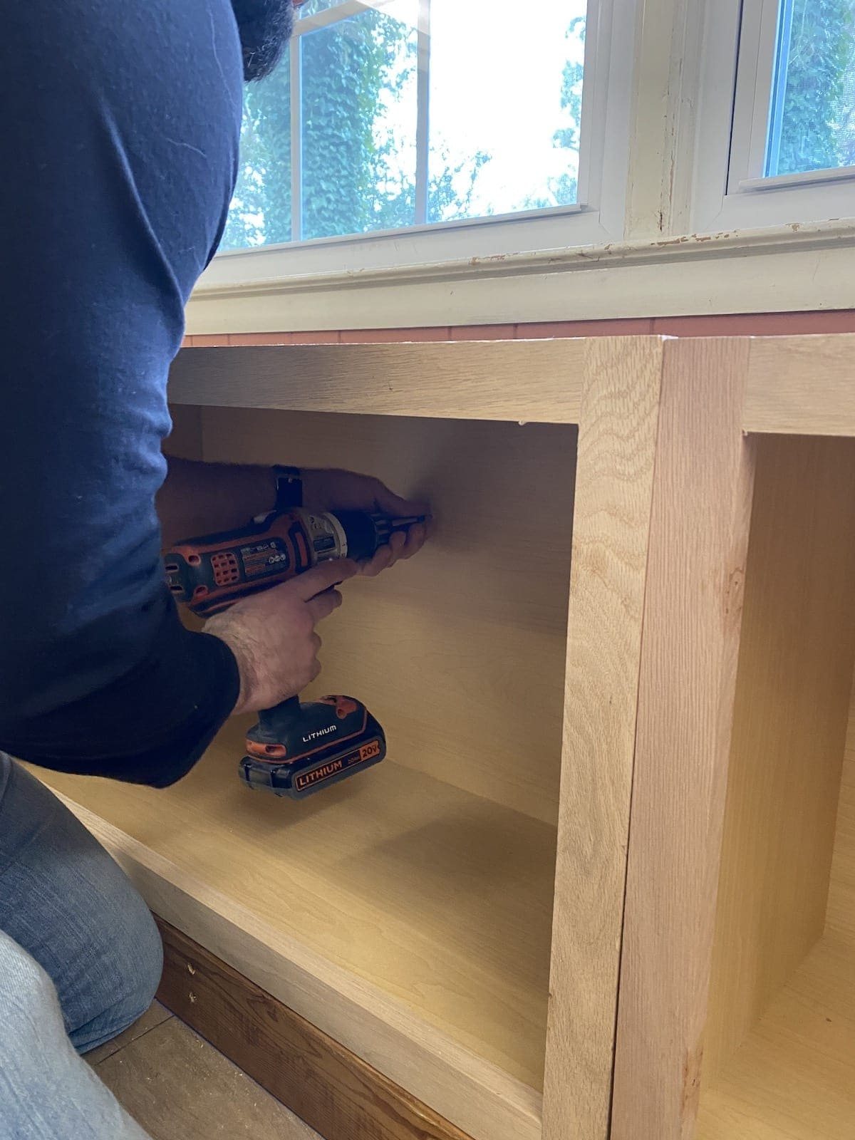 A step-by-step tutorial to build DIY built in cabinets and a window seat using inexpensive stock kitchen cabinets.