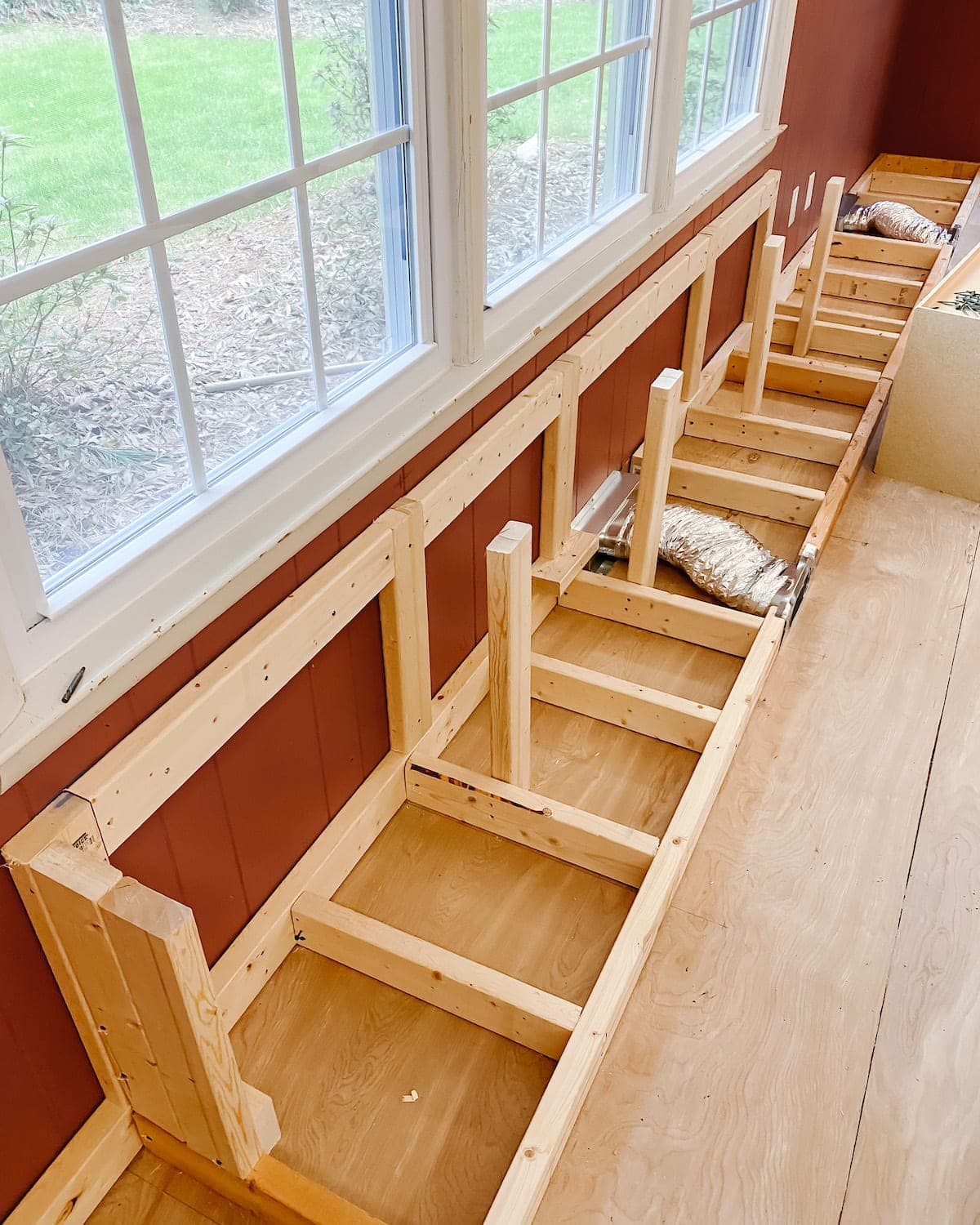A step-by-step tutorial to build DIY built in cabinets and a window seat using inexpensive stock kitchen cabinets.