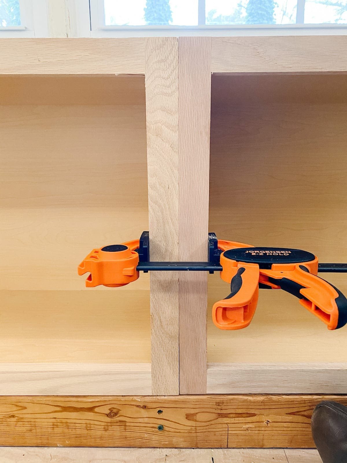 A step-by-step tutorial to build DIY built in cabinets and a window seat using inexpensive stock kitchen cabinets.