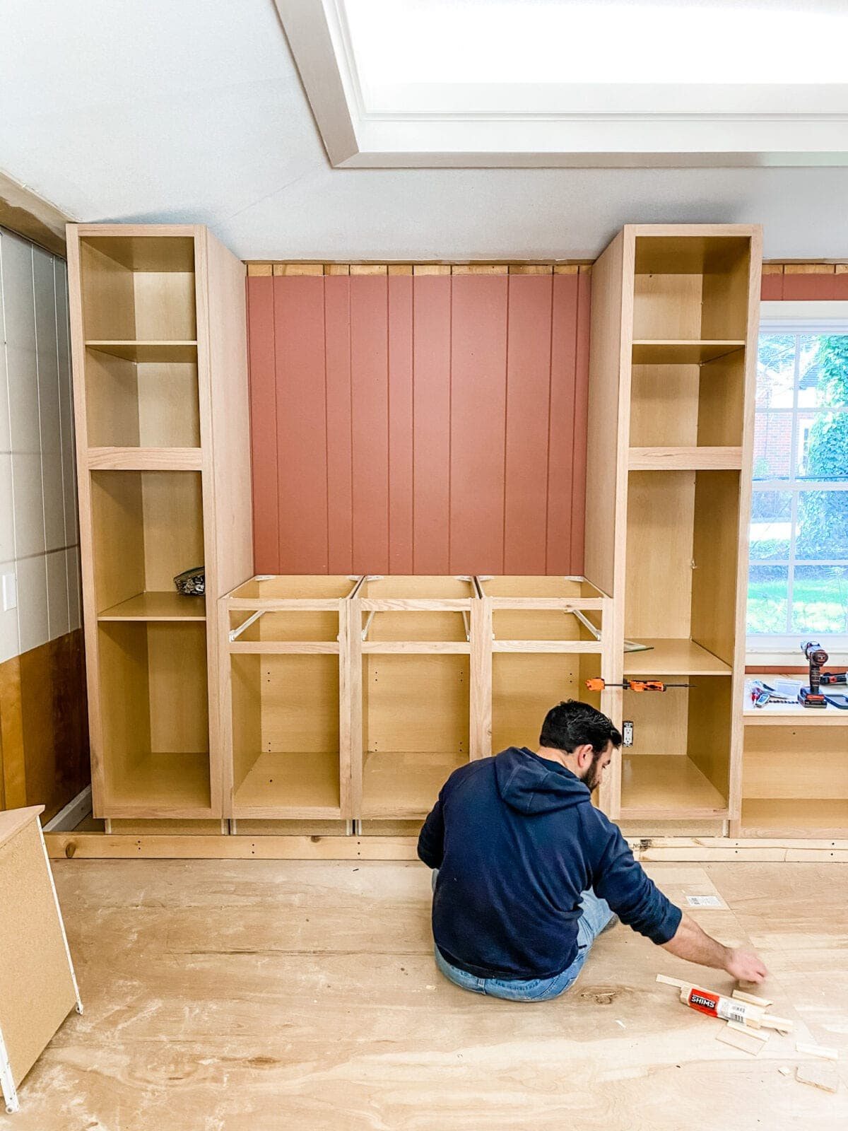 A step-by-step tutorial to build DIY built in cabinets and a window seat using inexpensive stock kitchen cabinets.