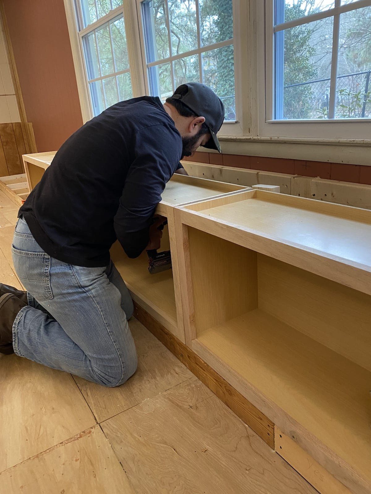 A step-by-step tutorial to build DIY built in cabinets and a window seat using inexpensive stock kitchen cabinets.