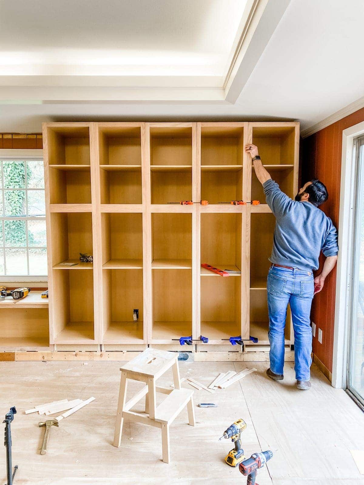 A step-by-step tutorial to build DIY built in cabinets and a window seat using inexpensive stock kitchen cabinets.