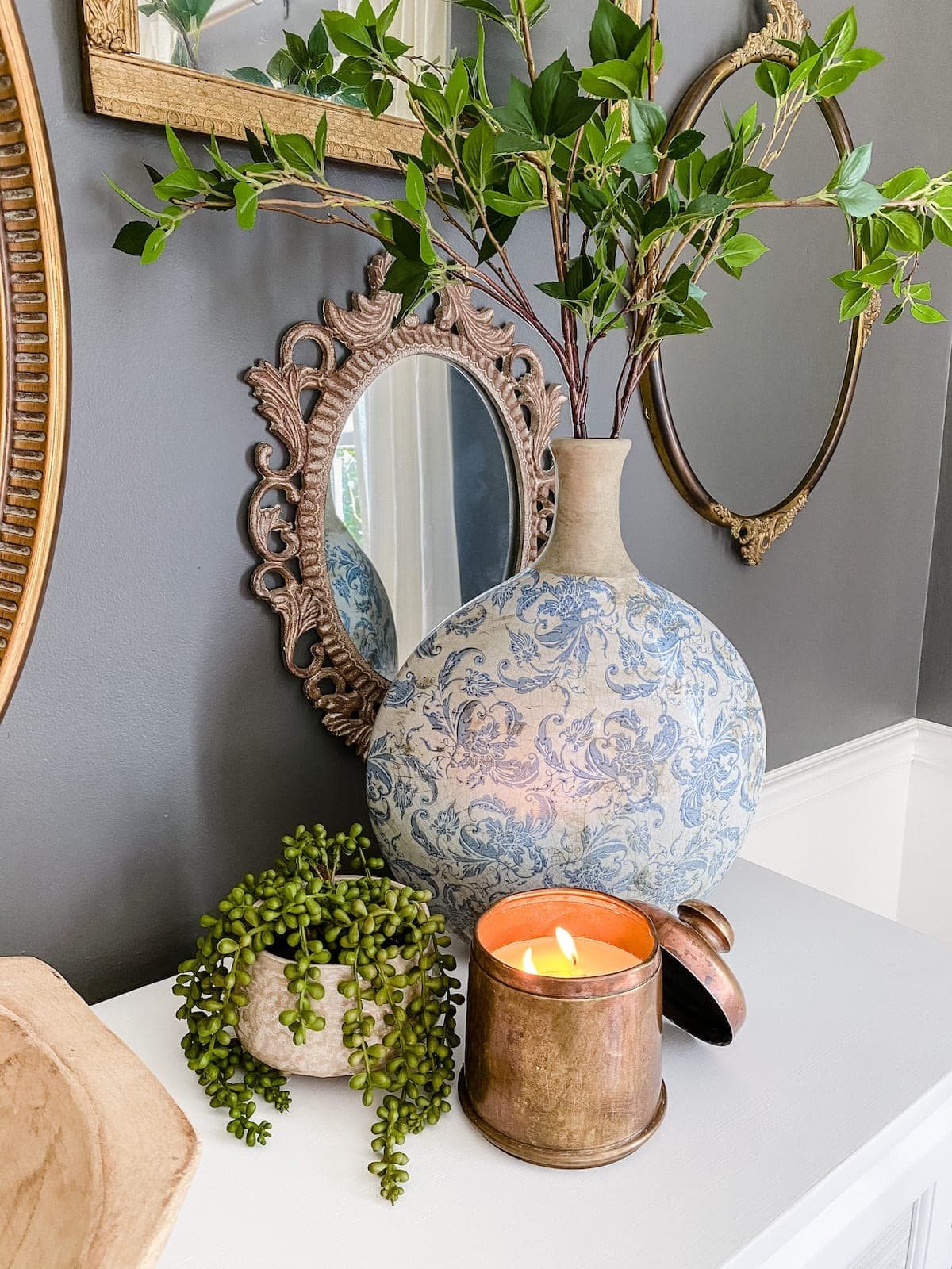 antique brass canister candle with Chinoiserie vase and greenery