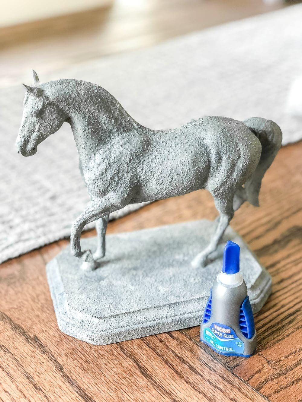 How to turn a toy horse figurine into a designer-inspired concrete equestrian statuette using just paint, wood craft, and glue. #thriftymakeover
