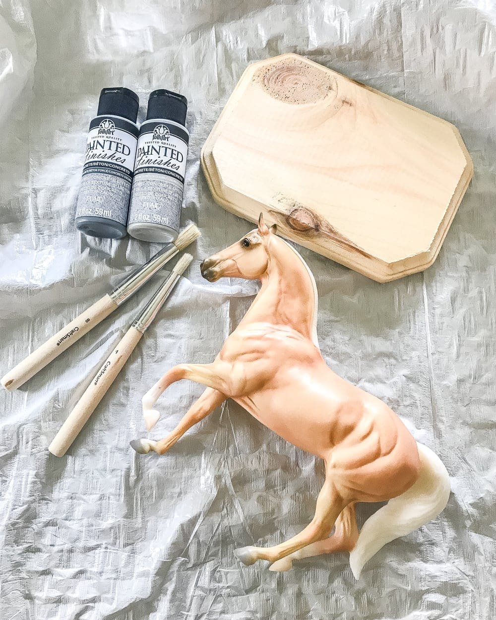 How to turn a toy horse figurine into a designer-inspired concrete equestrian statuette using just paint, wood craft, and glue. #thriftymakeover