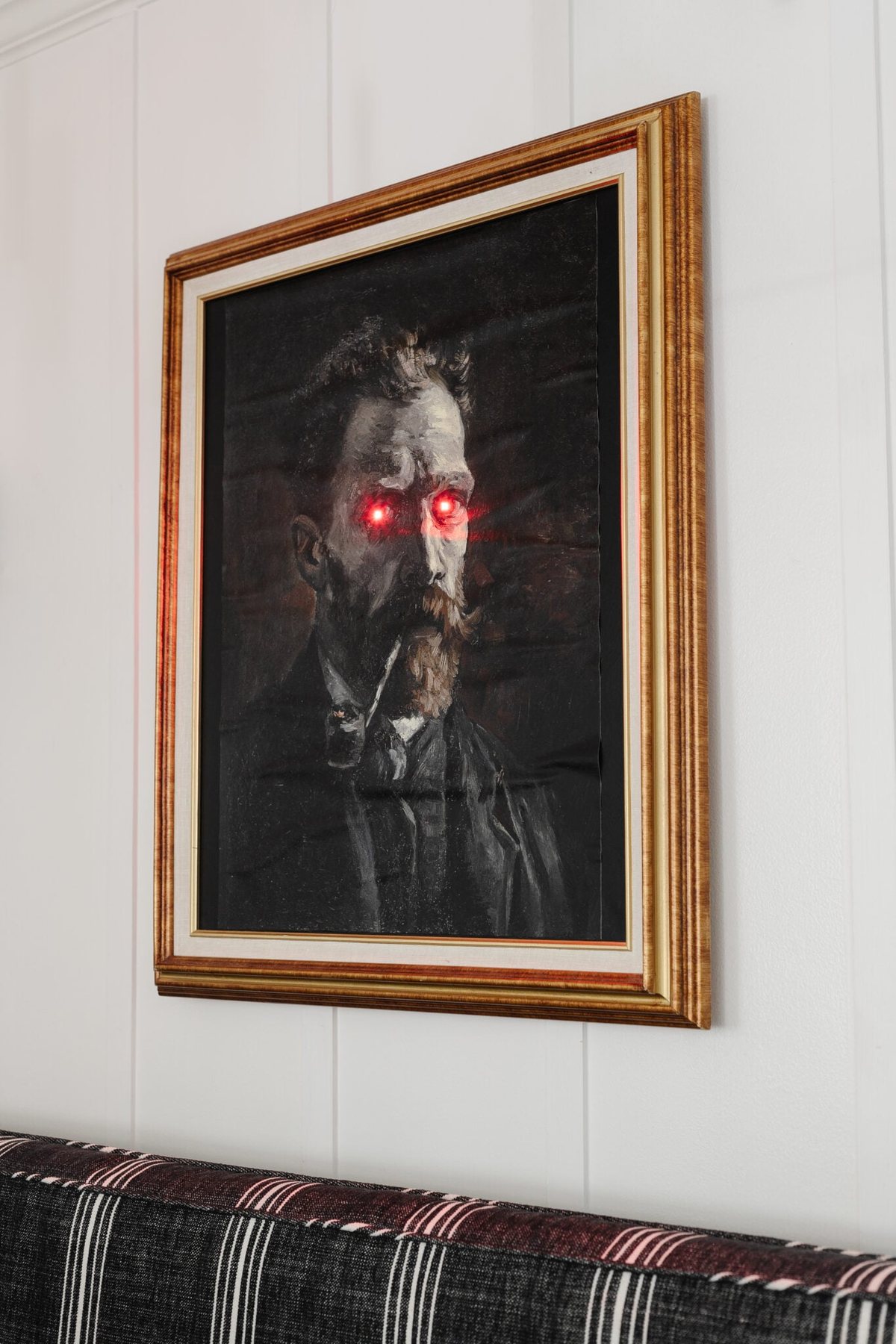 creepy Halloween art with glowing eyes in a gold picture frame for DIY Halloween wall decor