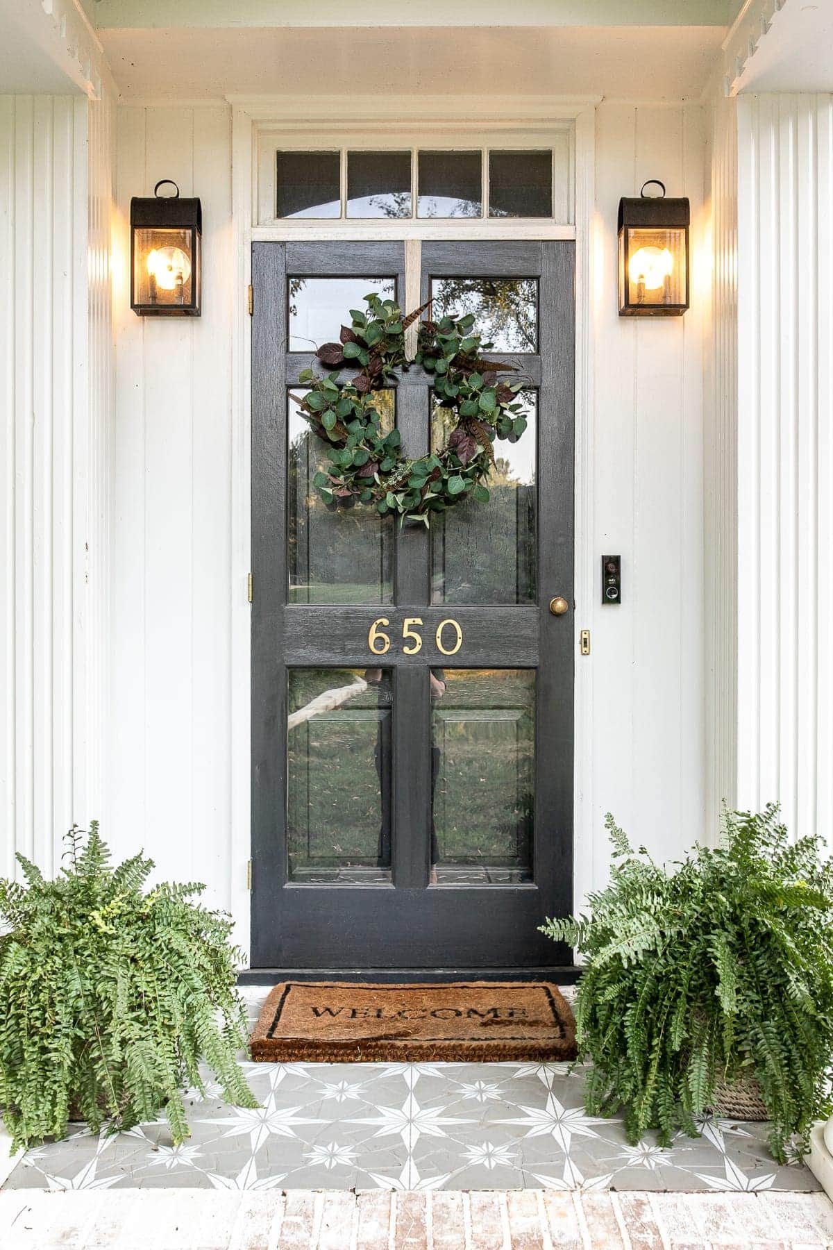 Front porch decorated for early fall with DIY wreath and stenciled floor