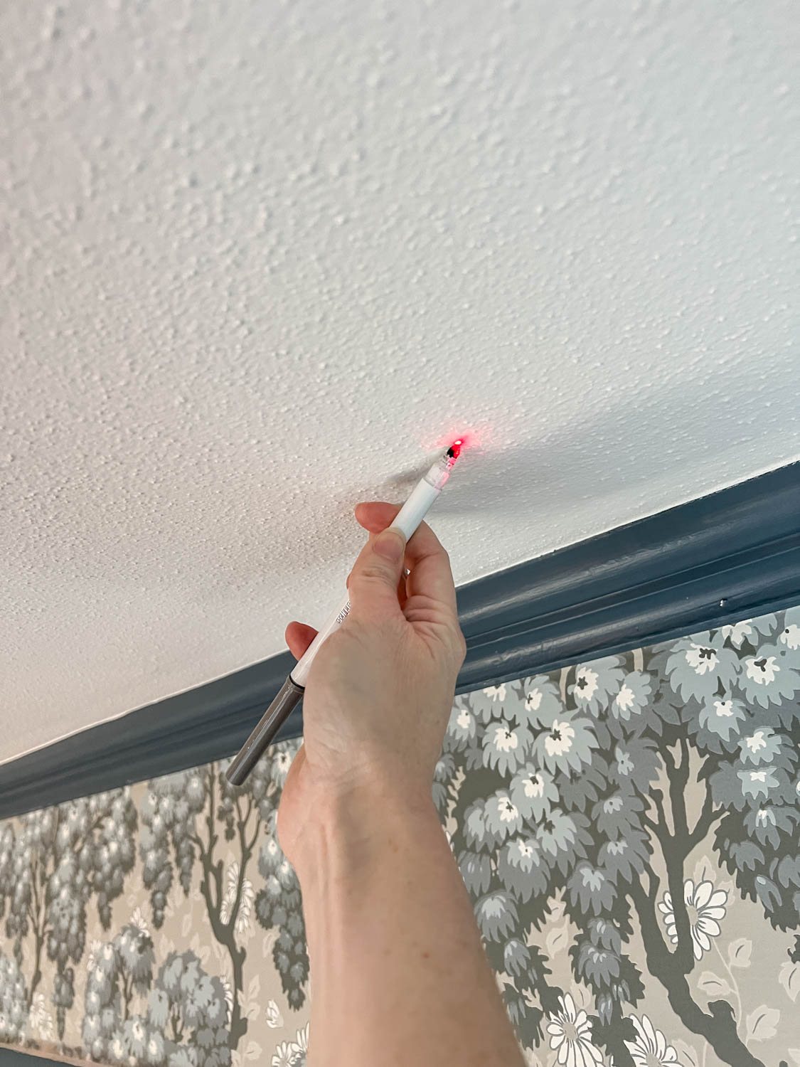 using a laser to mark vinyl decal placement on a ceiling