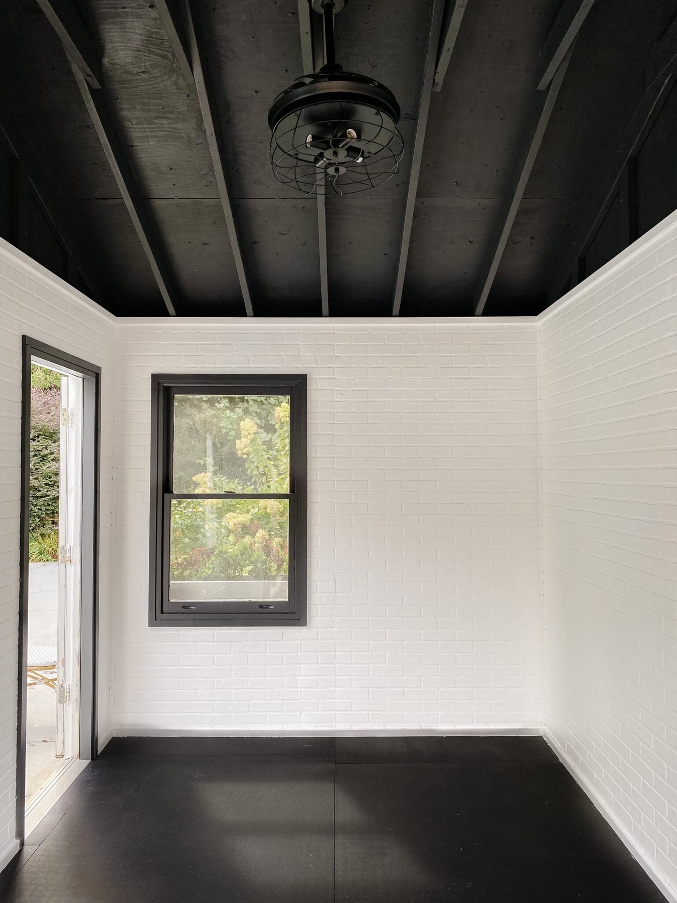 gym shed with white faux brick walls and black ceiling
