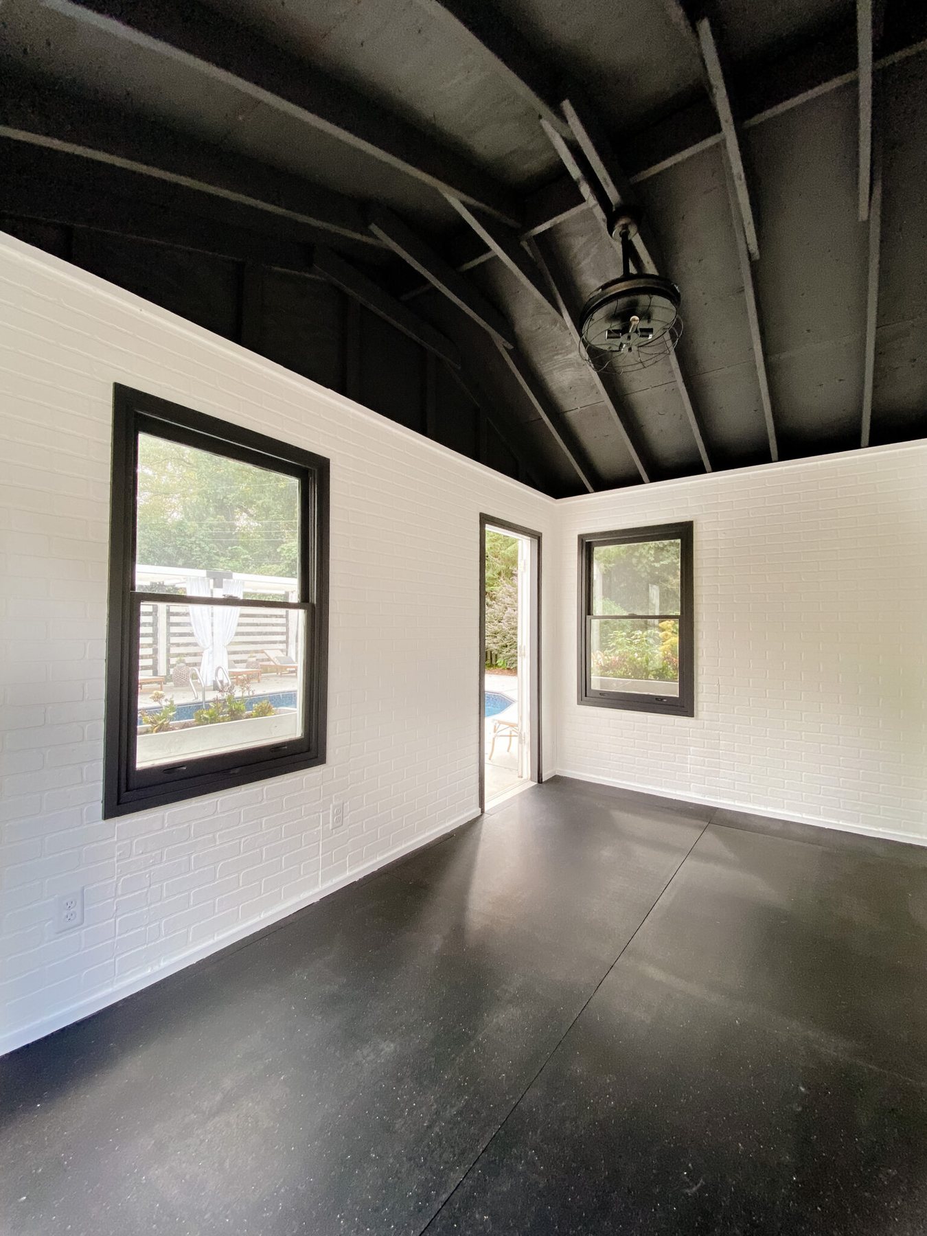 home gym with white faux brick wall panels and black ceiling