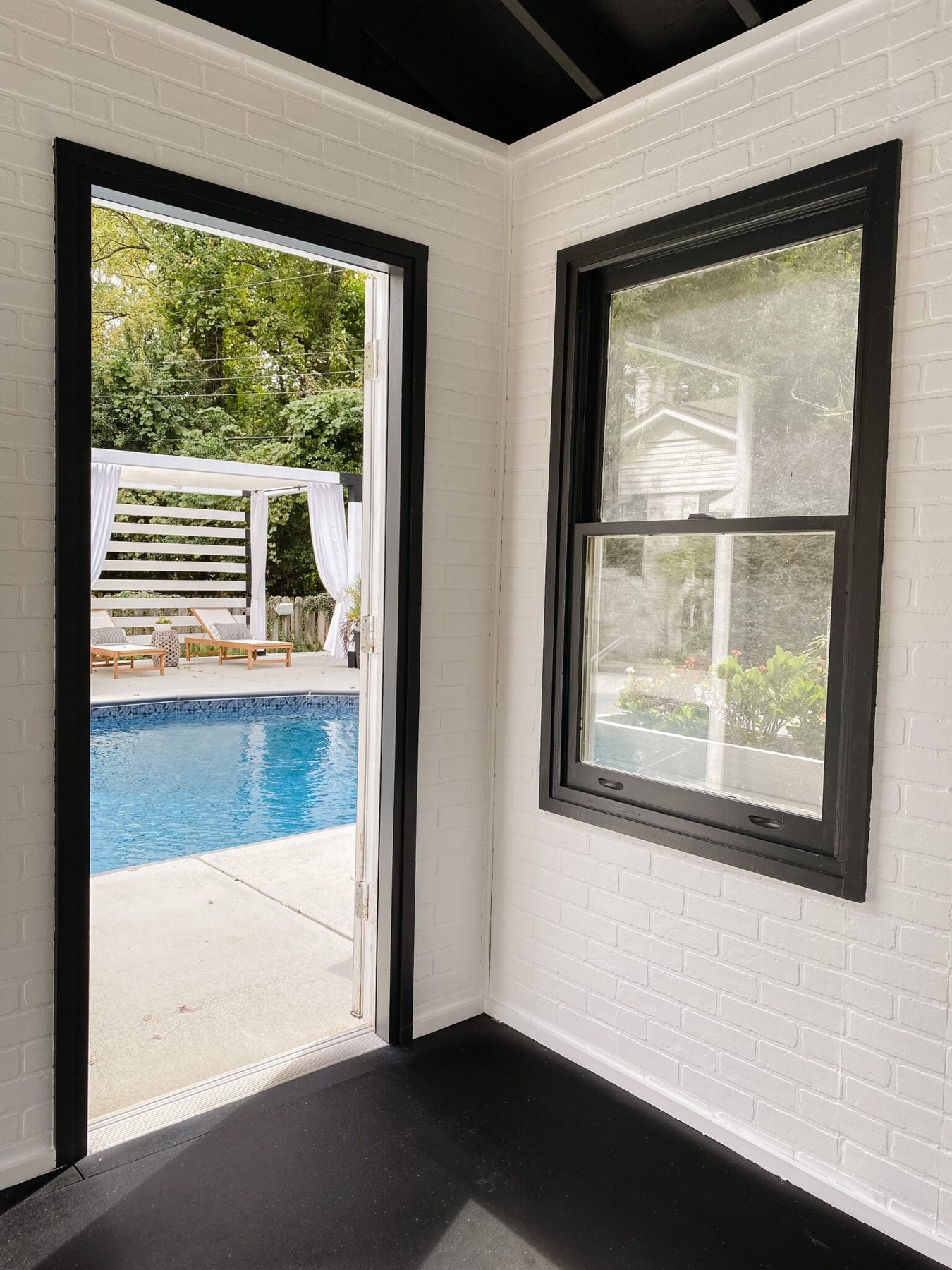 white brick walls and black trim in a poolside home gym
