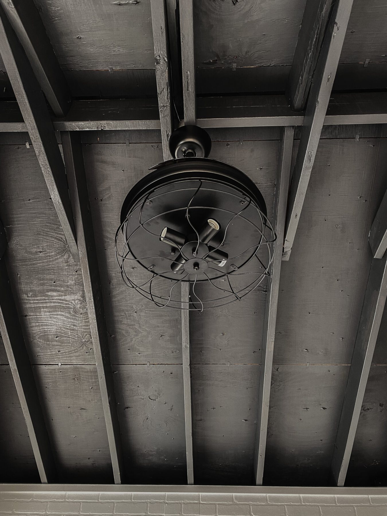 black ceiling with industrial retractable ceiling fan