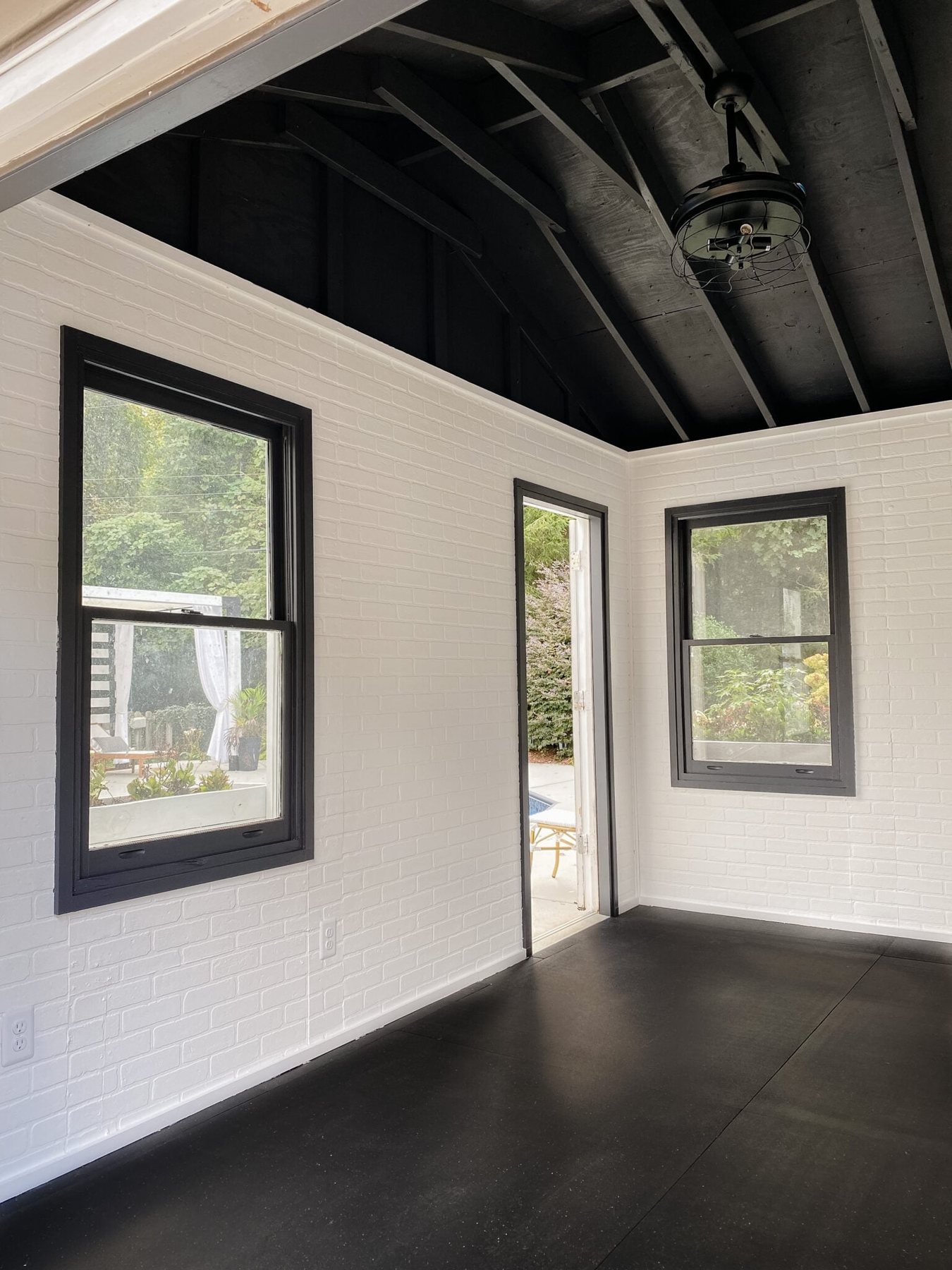 gym shed with white faux brick wall panels and black ceiling