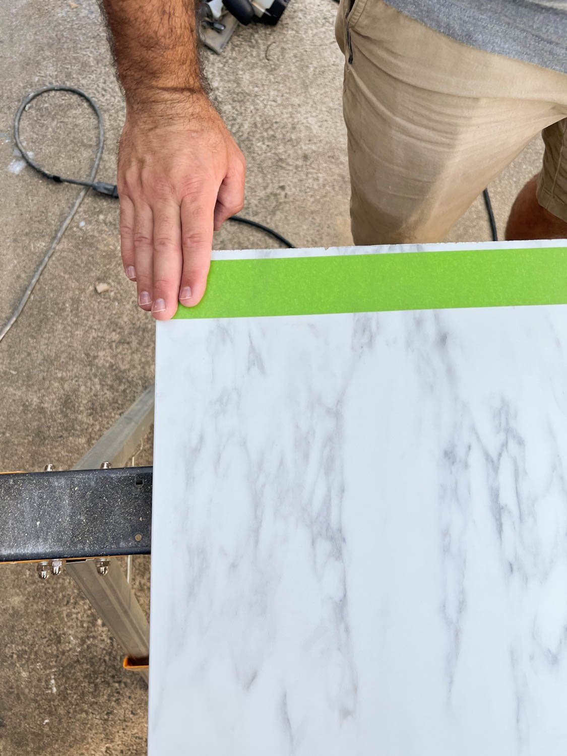putting masking tape on laminate faux marble countertop to be cut