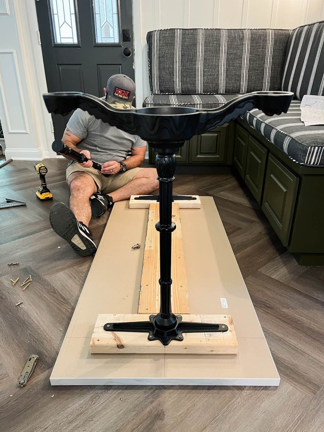 attaching 2x6 boards and cast iron pedestal legs underneath a countertop to make a faux marble dining table