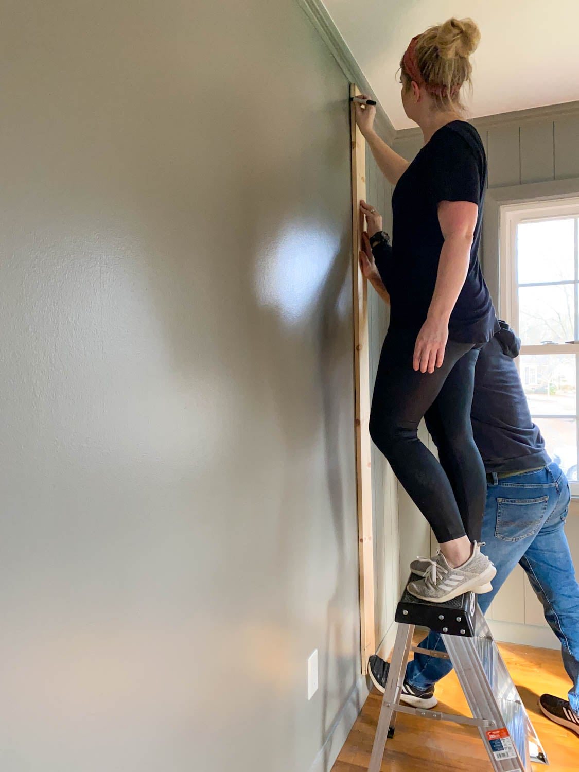 using 1x6 boards as spacers for tracing lines to mimic paneled walls with Sharpie paint pens