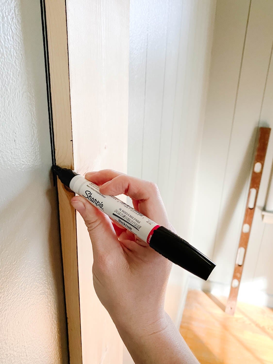 using a Sharpie paint pen to make lines for faux wall planking