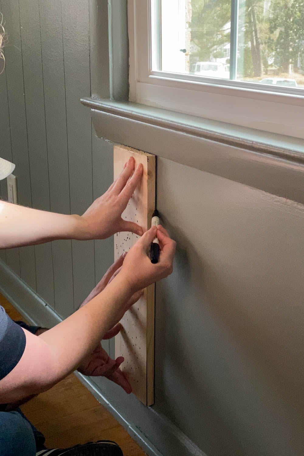Tracing 1x6 boards with Sharpie paint pens for faux paneled walls under a window