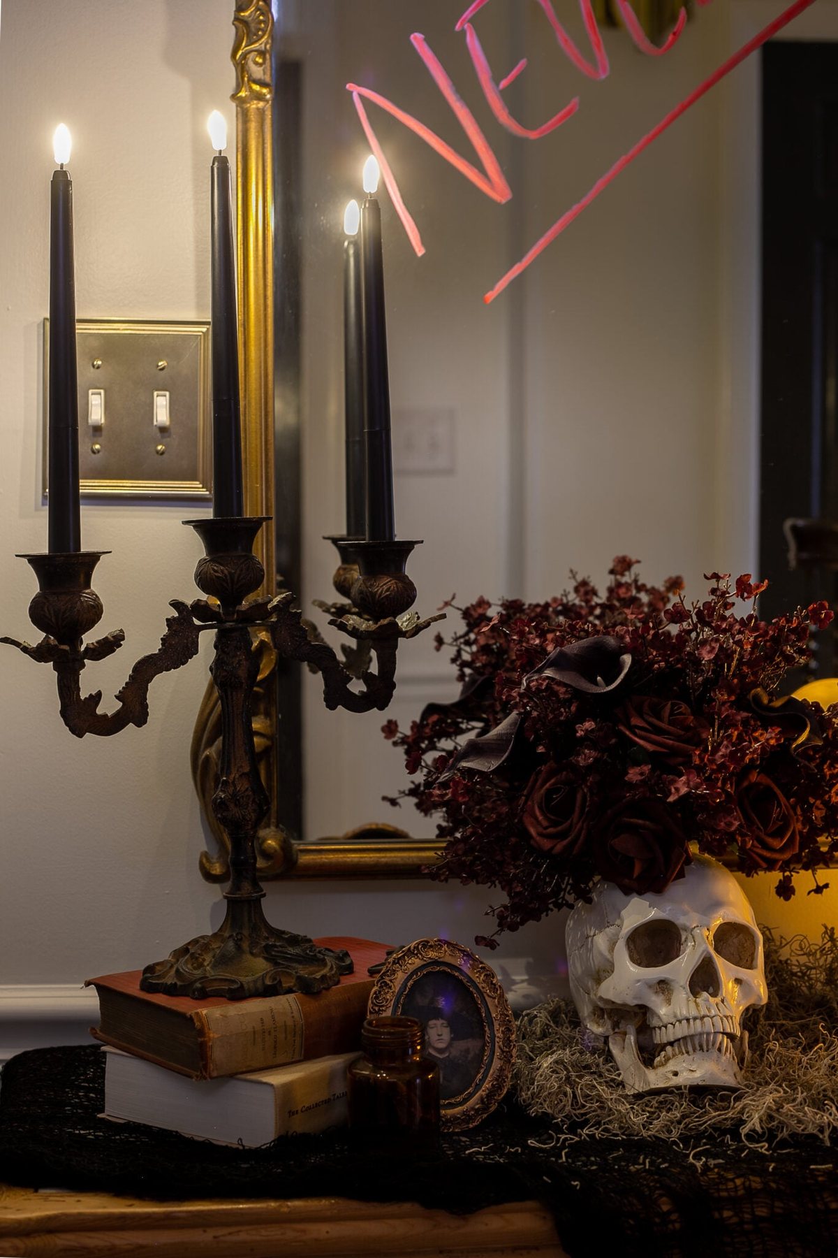 candelabra with flameless candles, vintage picture frame, and skull vase