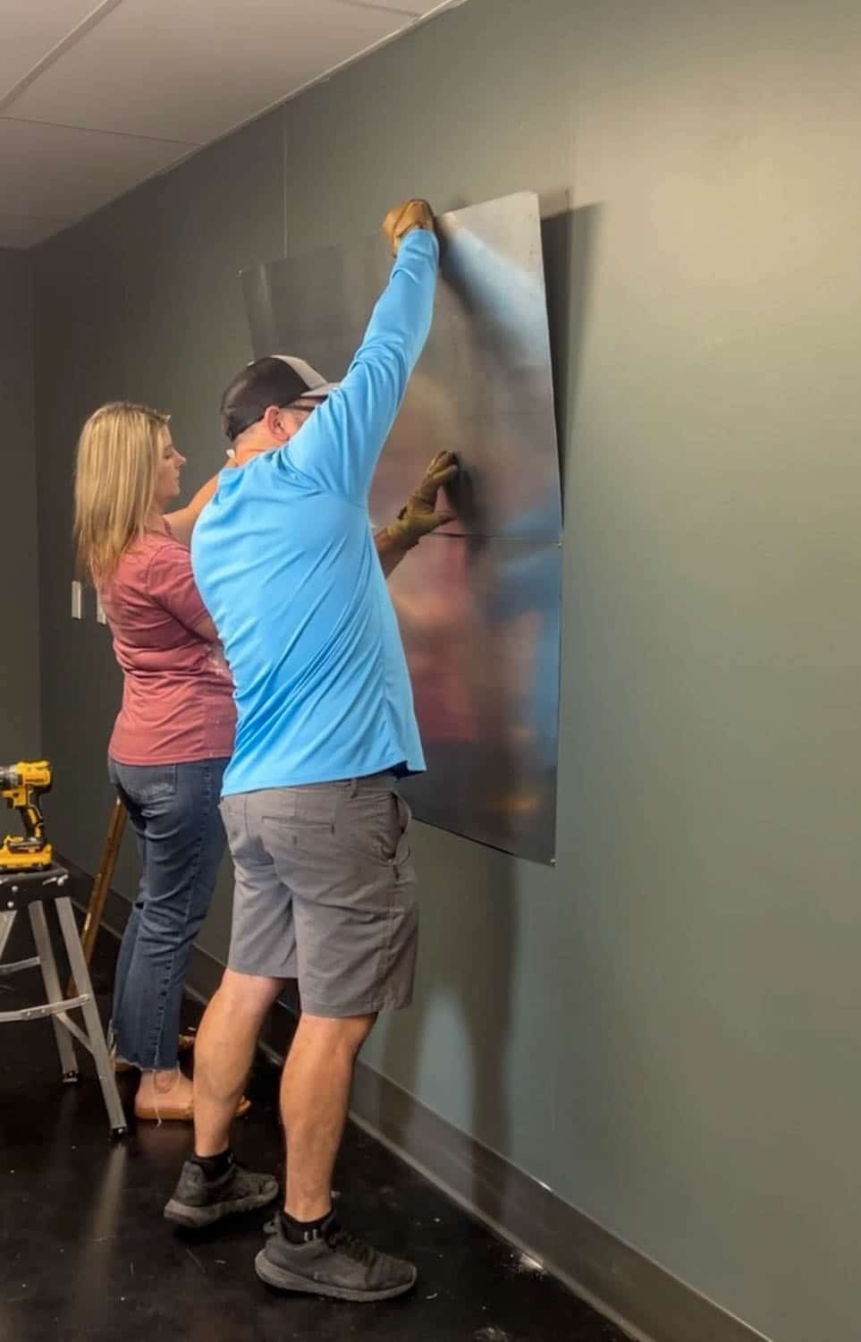 placing metal sheets on a wall to make a magnetic notice board