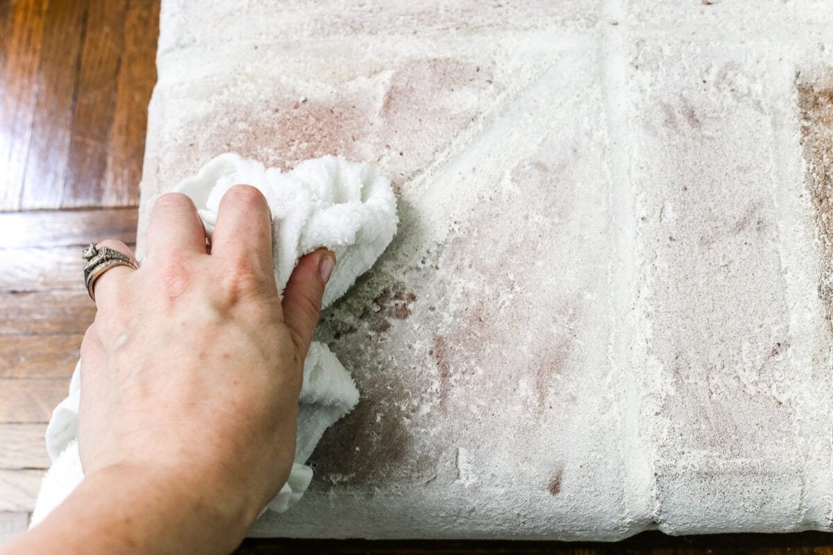 removing lime wash from bricks on a fireplace to distress