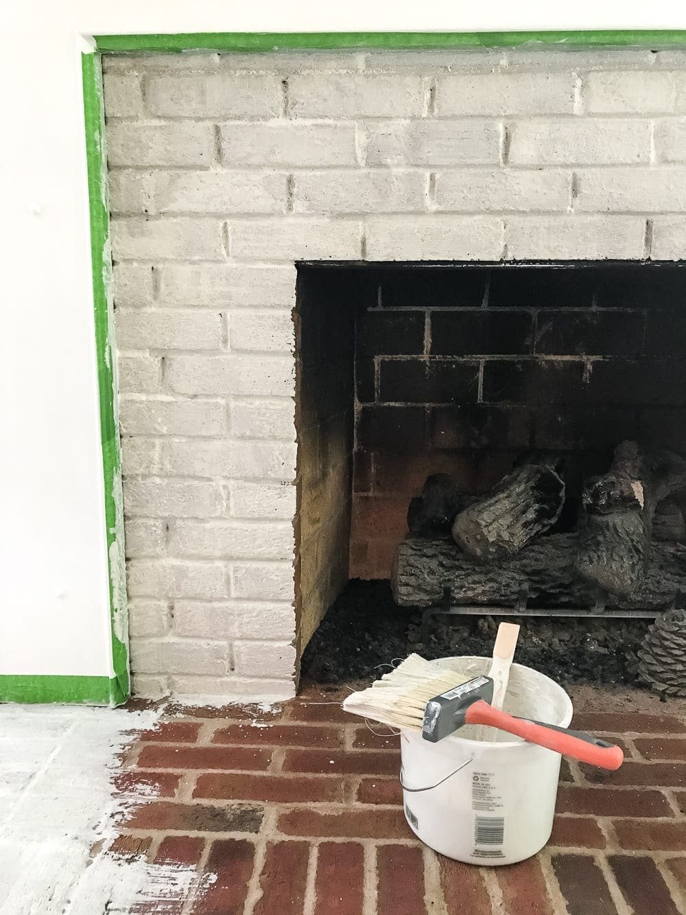 painting lime wash on natural bricks on a fireplace