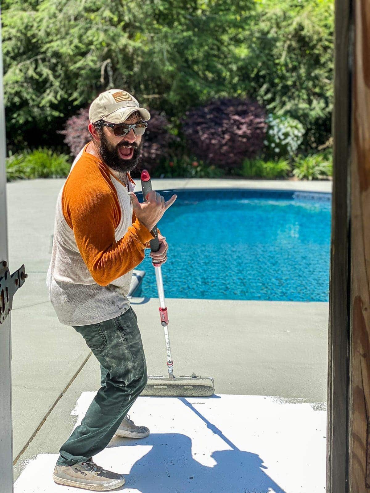 applying concrete paint around a pool deck