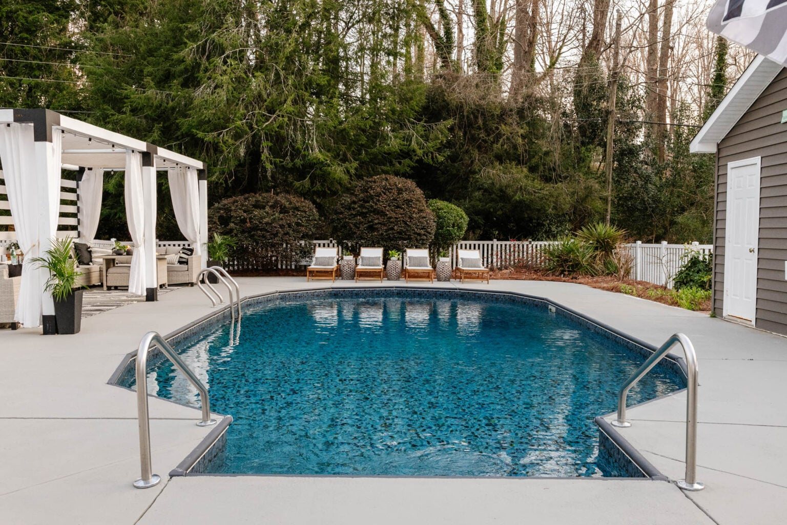 finished painted concrete pool deck and patio with pergola cabana and pool furniture