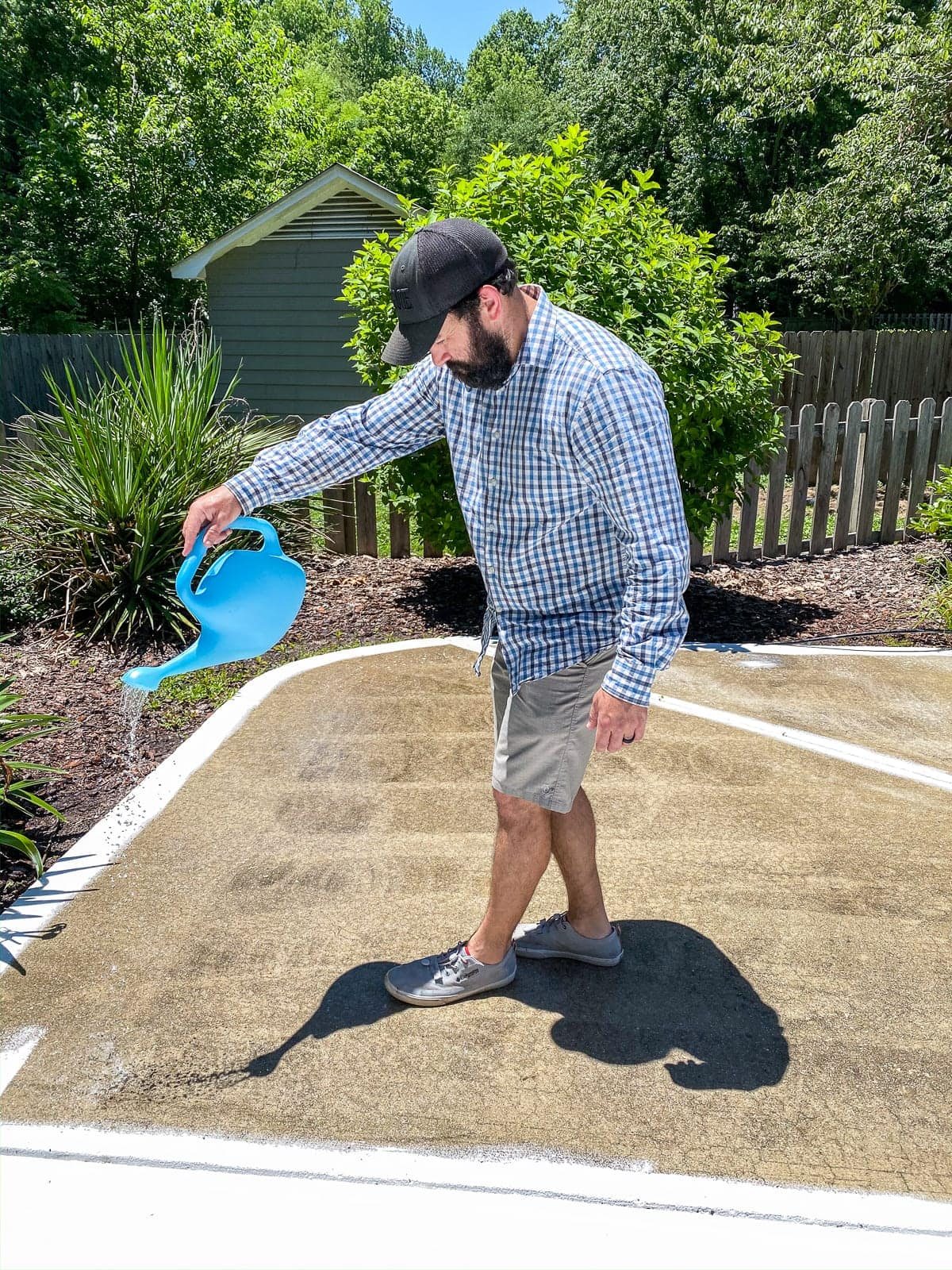 applying concrete etcher and cleaner with a watering can